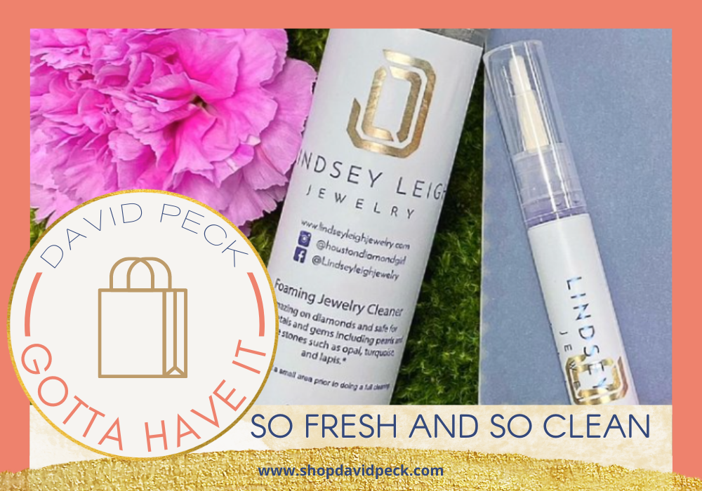 Gotta have it. Lindsey Leigh Jewelry LLJ cleaner laying next to a white rose with a diamond engagement ring nestled in it's petals.
