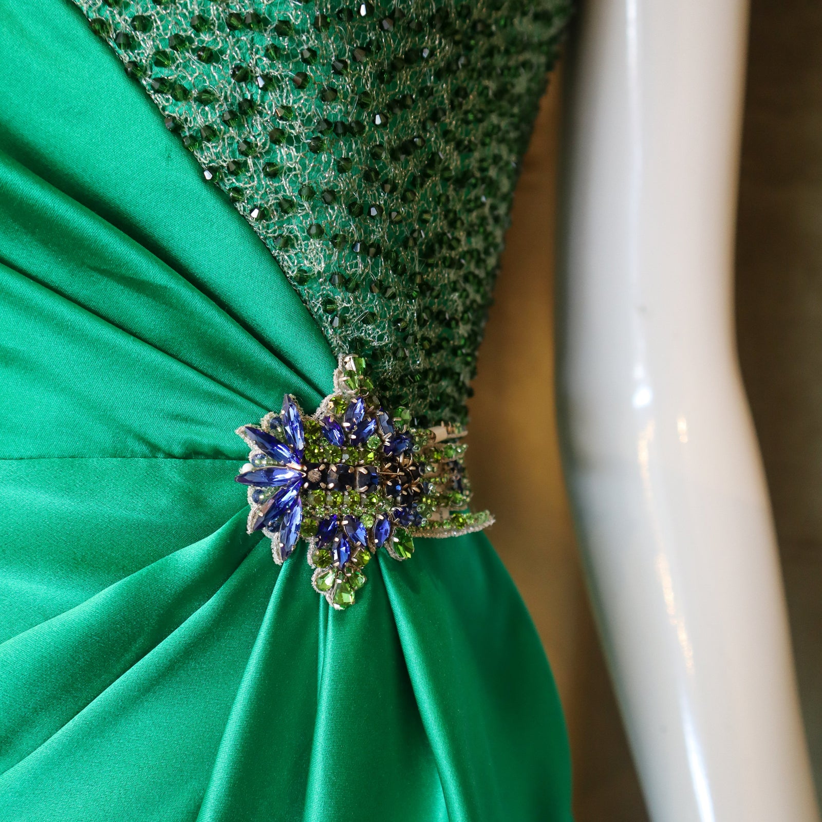 Green dress with a decorative brooch on a mannequin