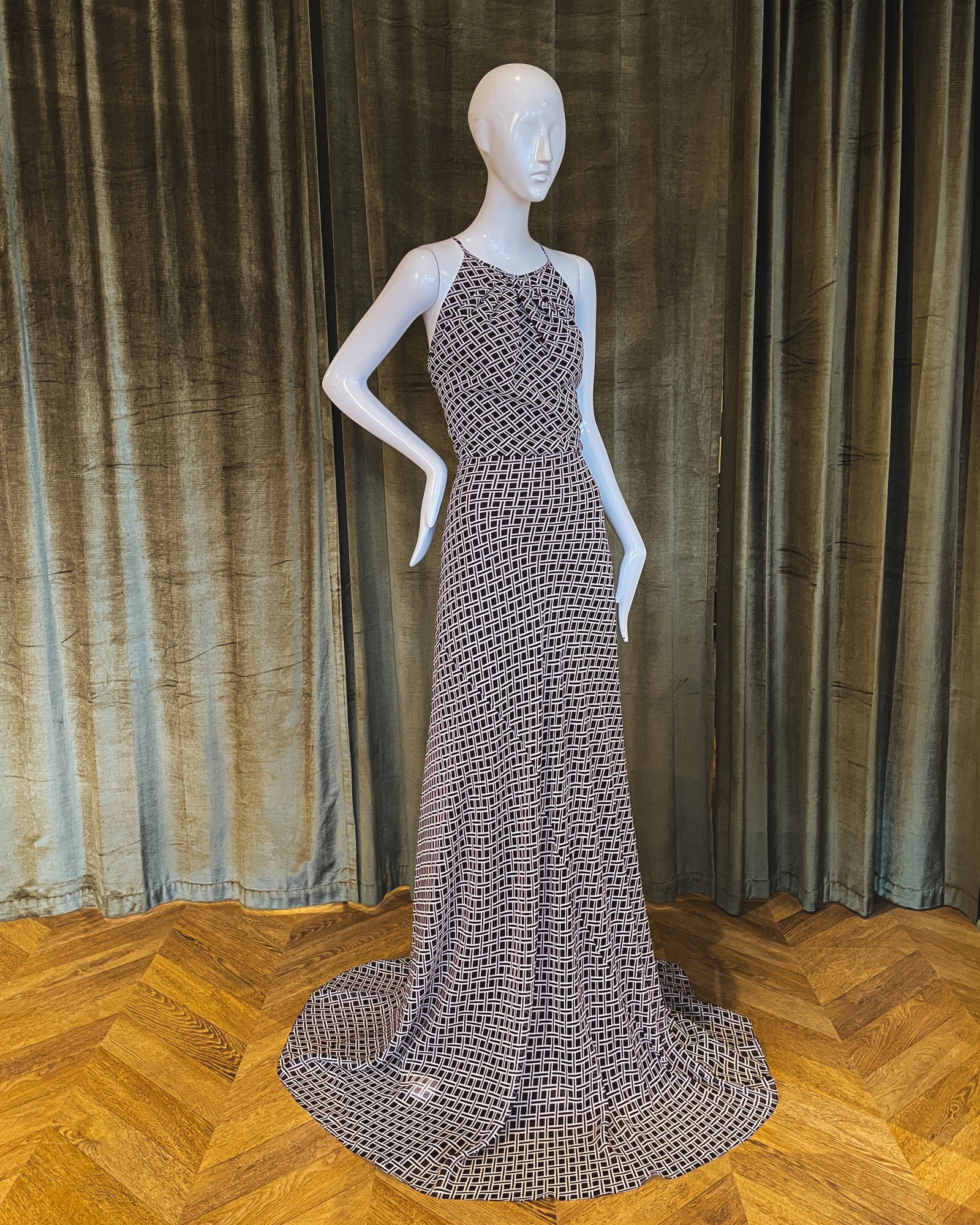 A Santa Fe Gown featuring a chocolate lattice work design, displayed on a mannequin against a dark background. Designed by David Peck.