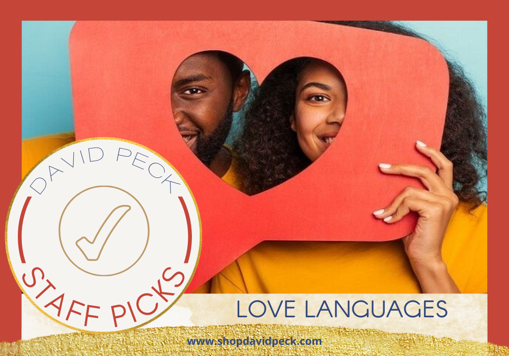 staff picks. black couple wearing yellow shirts holding a red board with a heart cut out over their faces