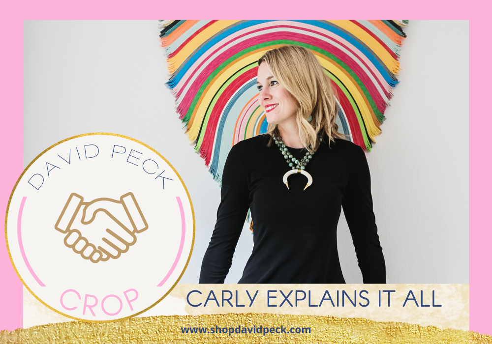 CROP. Blonde woman in black dress sitting in front of rainbow wall art.