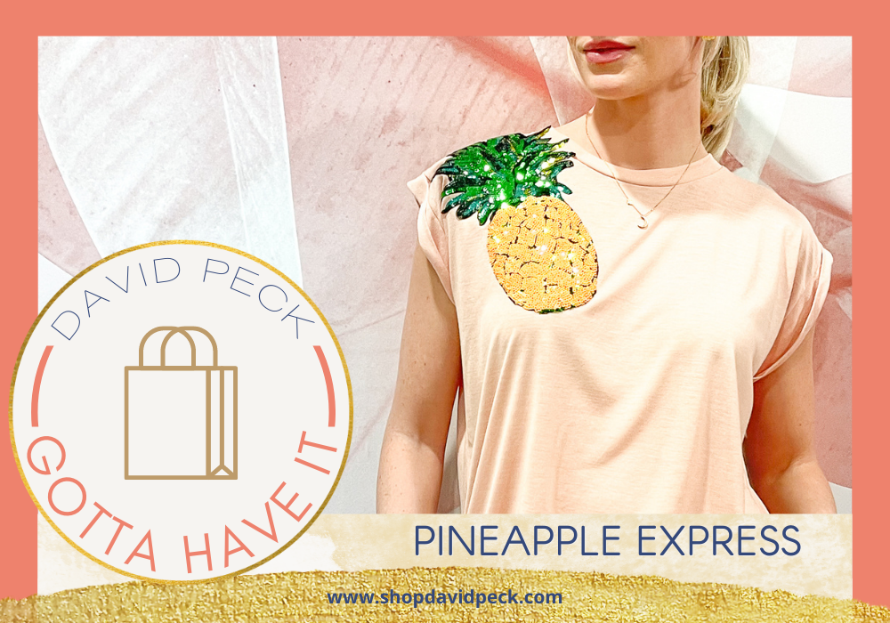 Gotta Have It. Blonde woman with pink lip wearing a pink T-shirt with a sequin pineapple on it. 