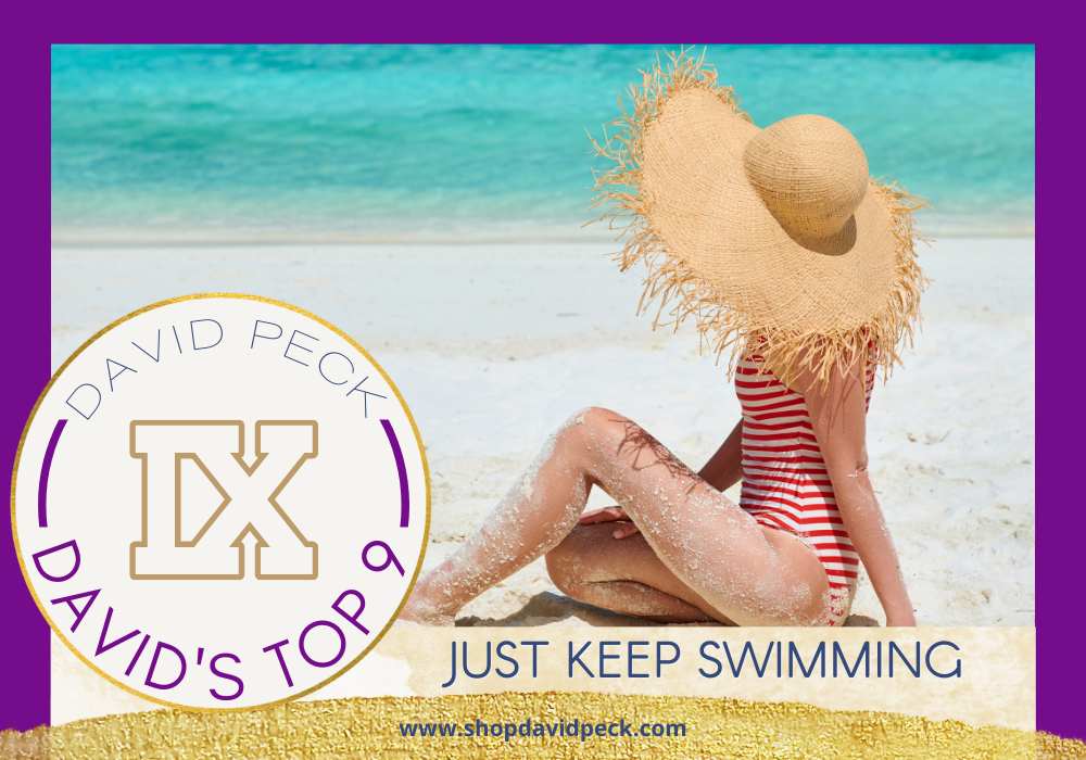 David's top 9. Woman sitting on a beach with a red and white striped one piece swimsuit wearing a large brim straw hat