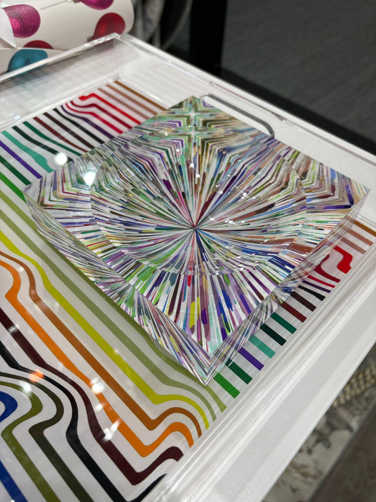 Colorful abstract design on a glass surface with a white frame.