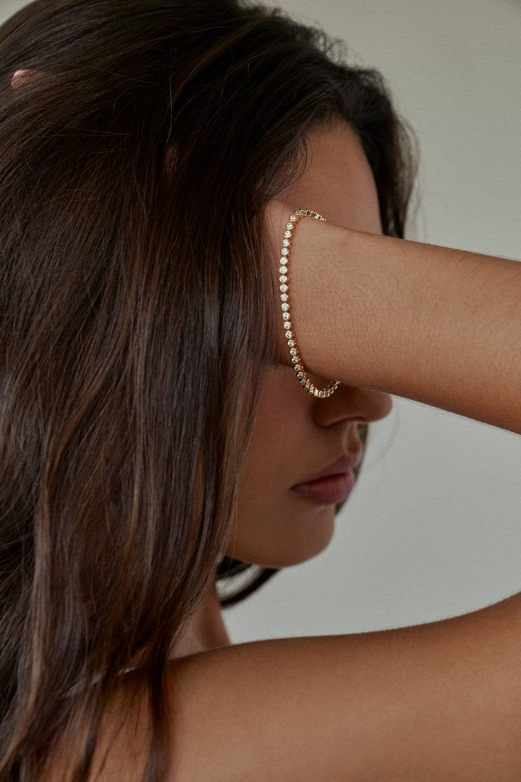 Silver bracelet with clear stones on a white background