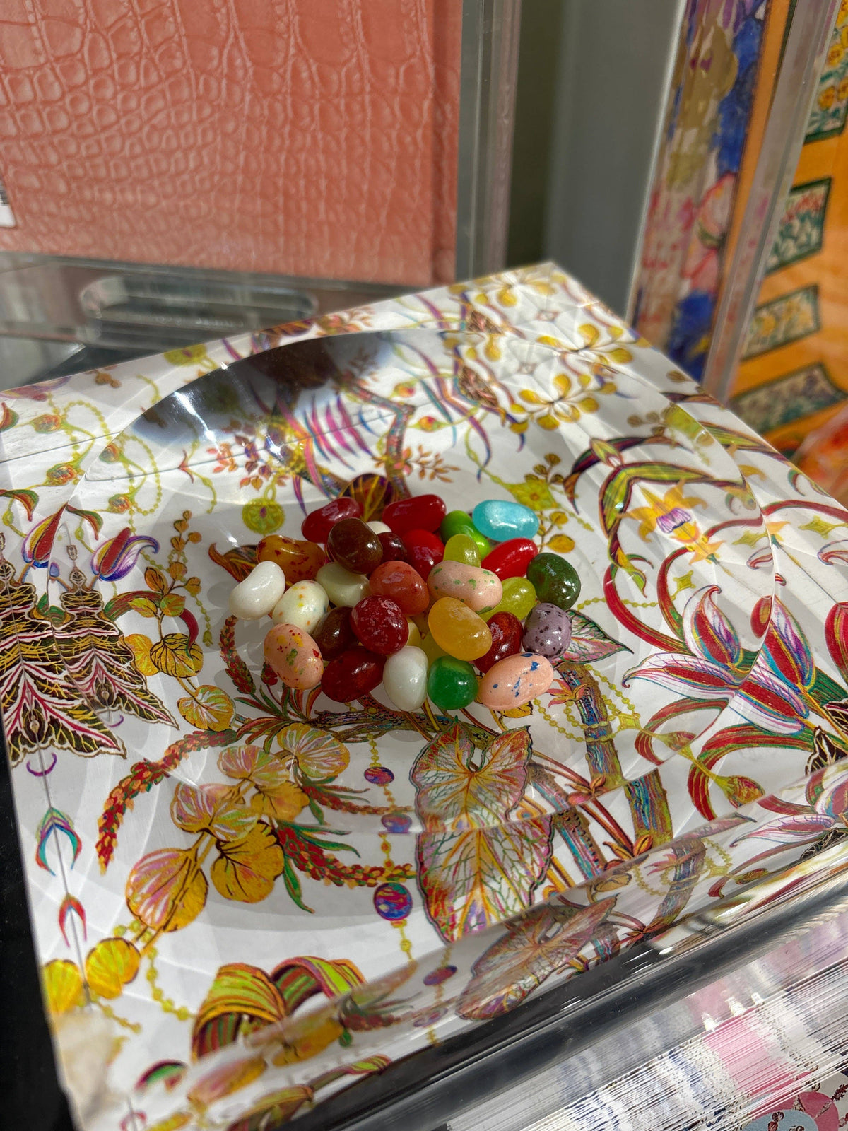 Colorful jelly beans on a decorative glass plate with floral pattern