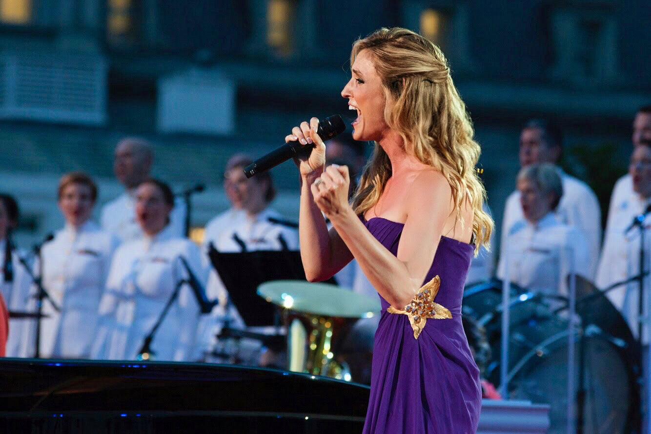 Kelly Levesque, a singer and songwriter, in a custom designed strapless purple gown with a star on the side by David Peck, singing at the KNOWAutism gala on the fourth of July.
