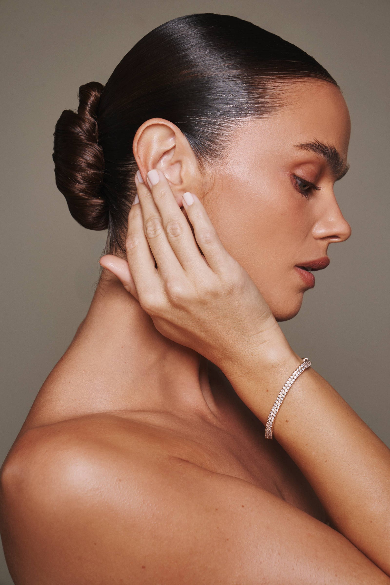 Gold bracelet with clear stones on a light gray background